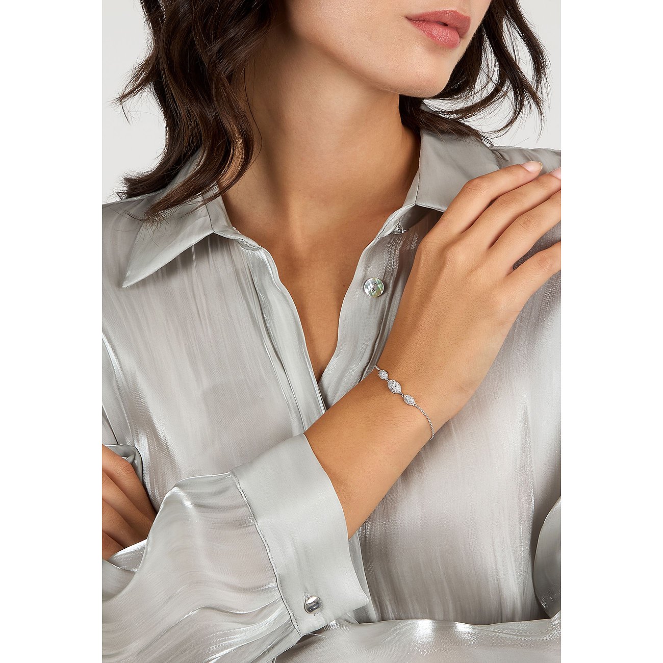 Een vrouw draagt een zilveren Morellato armband van gerecycled zilver met fonkelende zirkonia stenen.