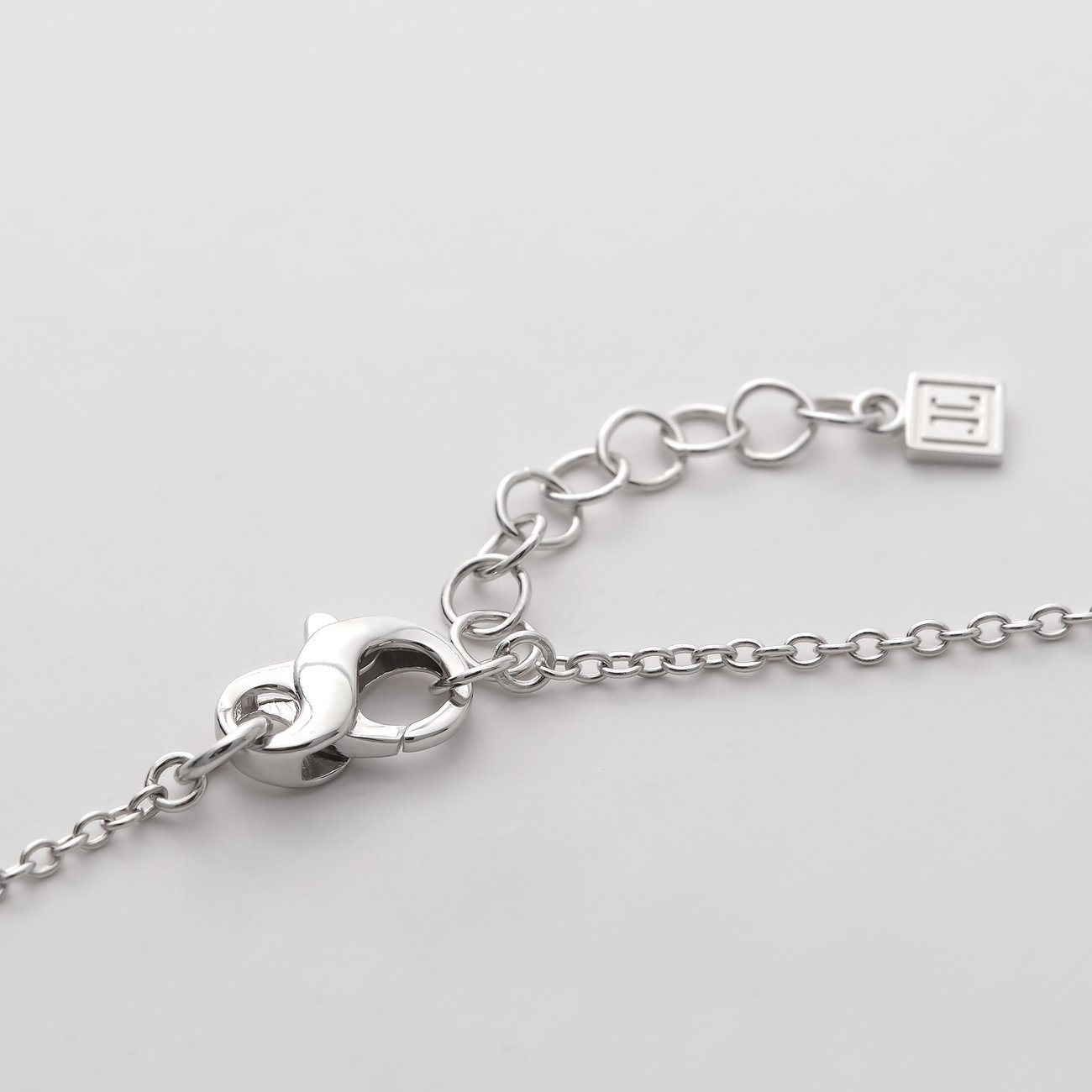 Gros plan sur le fermoir d'un bracelet JETTE en argent recyclé avec rallonge et chaîne à maillons ancre.