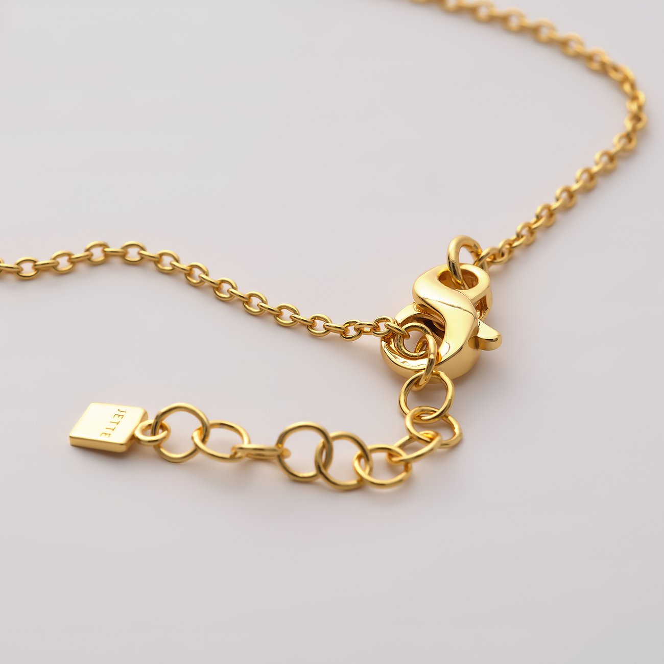 Gros plan sur le fermoir d'un bracelet or JETTE en argent recyclé. Petit rectangle affichant la marque JETTE.