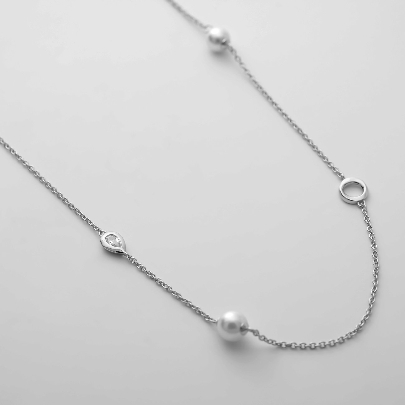 JETTE Halsschmuck aus recyceltem 925er Silber mit Perlen und tropfenförmigen Steinen leicht schräg von oben.