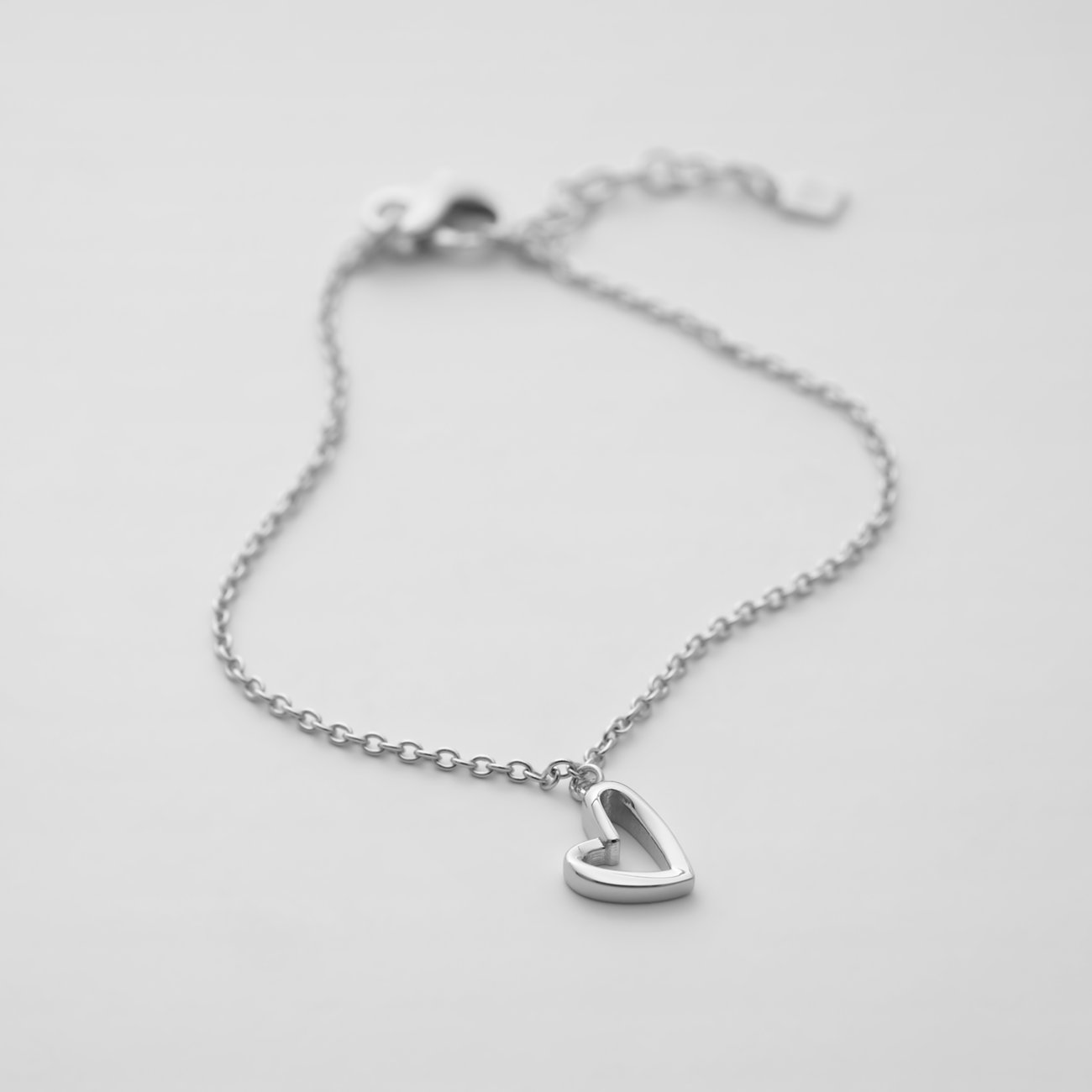 JETTE recyceltes 925er Silber Armband mit filigraner Kette und Herzanhänger, aus der Vogelperspektive.