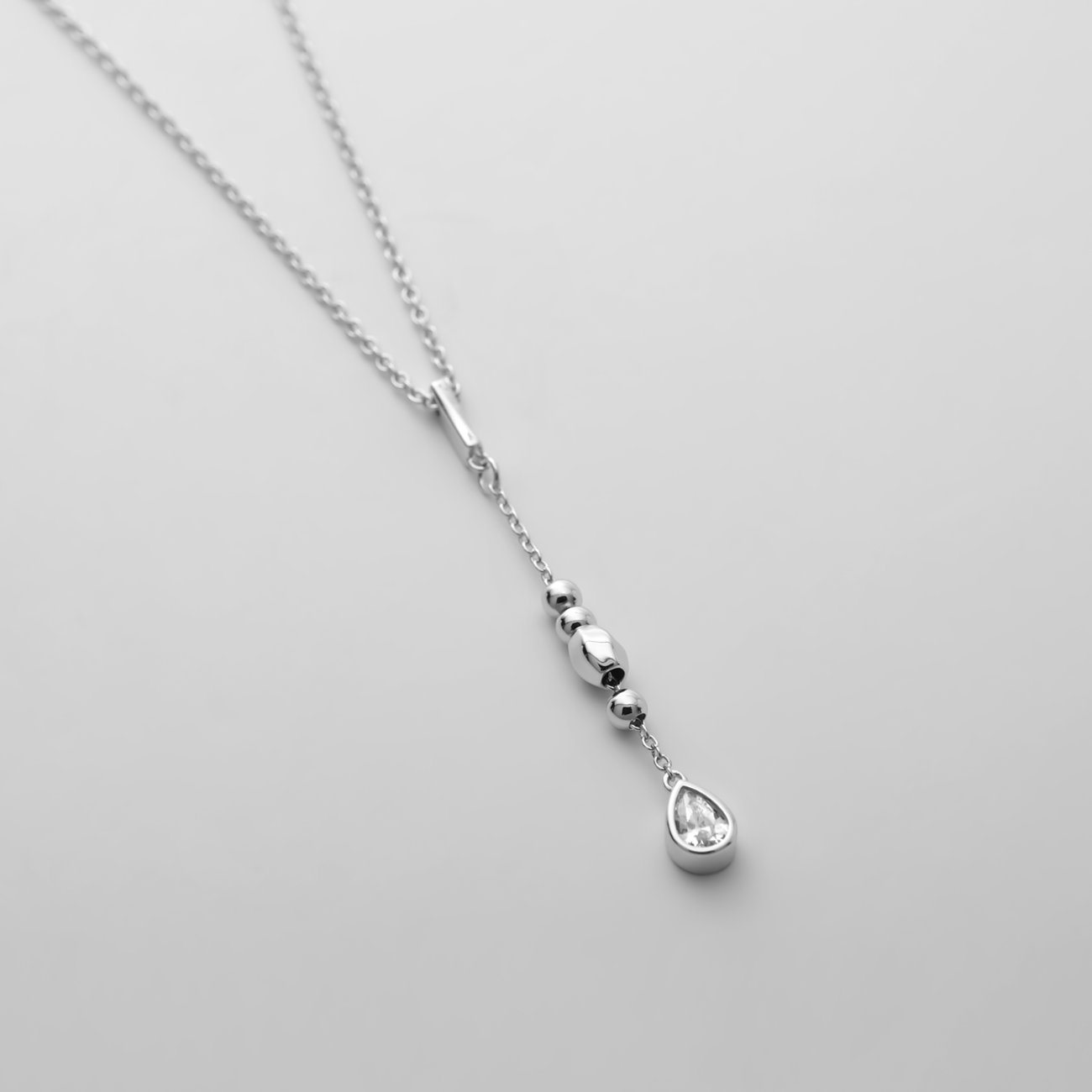 JETTE Halsschmuck aus recyceltem 925er Silber mit mehreren kleinen Silberperlen und einem Zirkonia-Tropfenanhänger.