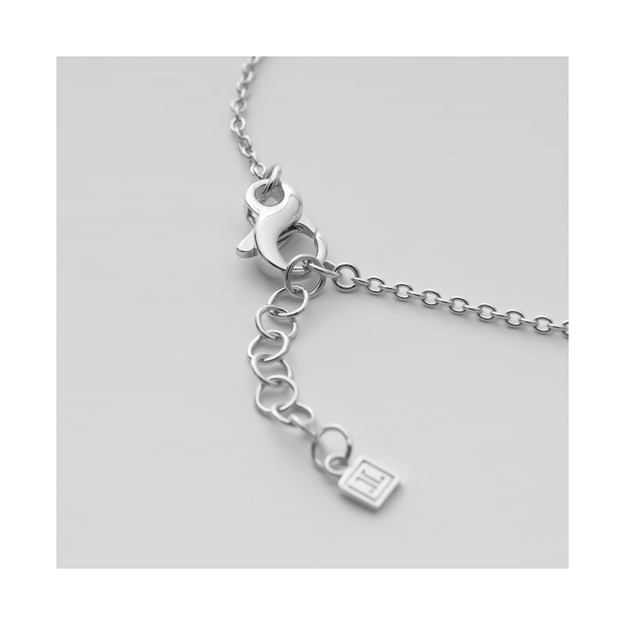 Nærbillede af lukkemekanismen og forlængerkæden på et sølvfarvet JETTE armbånd med et lille mærkevedhæng.