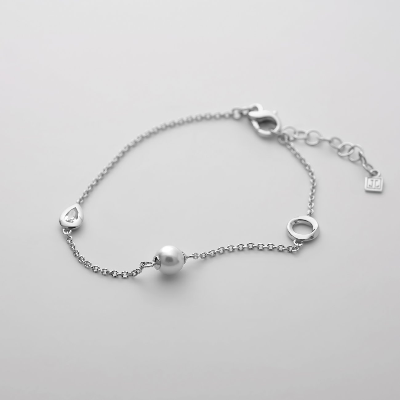 JETTE armlänk i återvunnet silver med en central pärla och droppformade element.