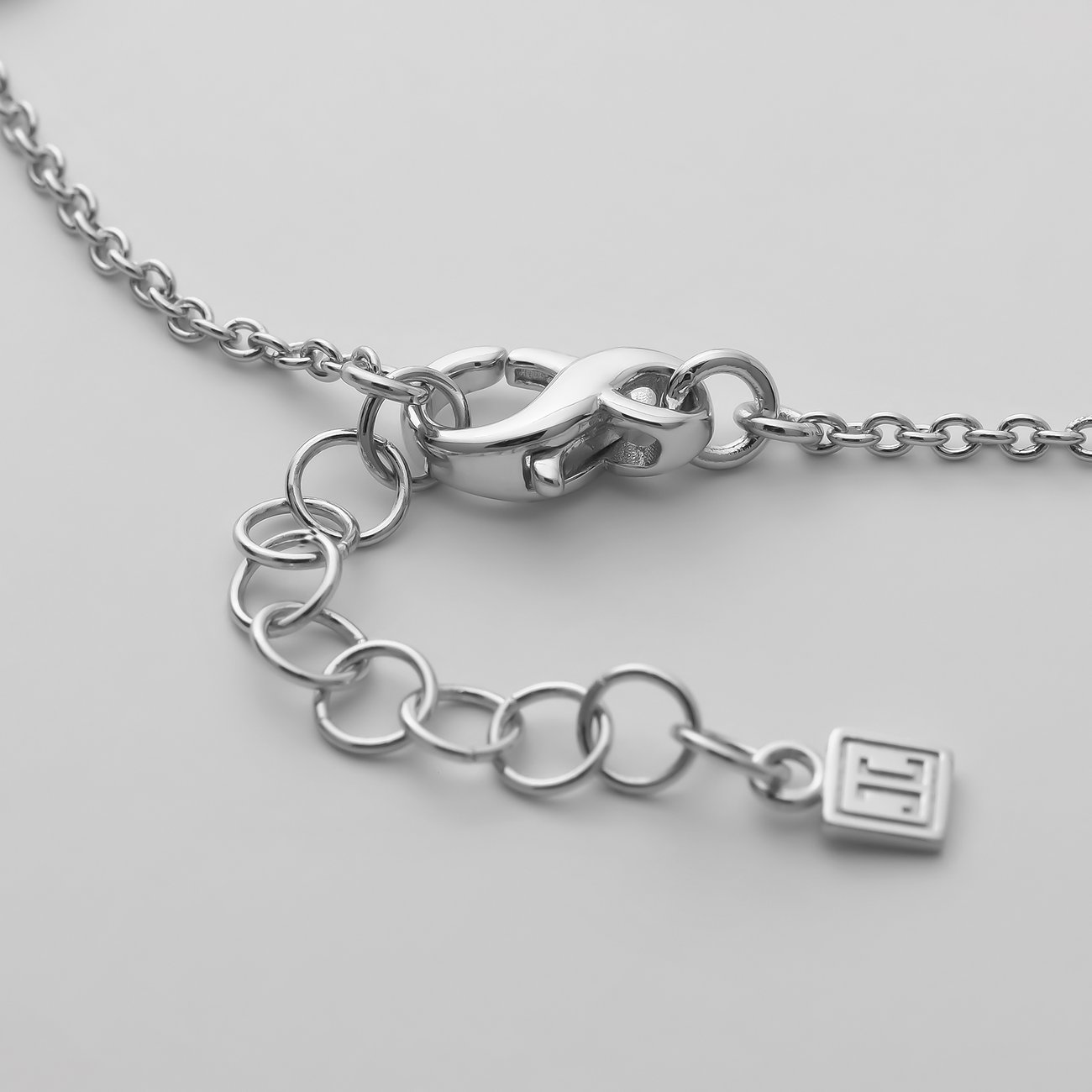 Närbild av låset på ett JETTE armbandsmycke i återvunnet 925 silver med förlängningskedja och pärla.