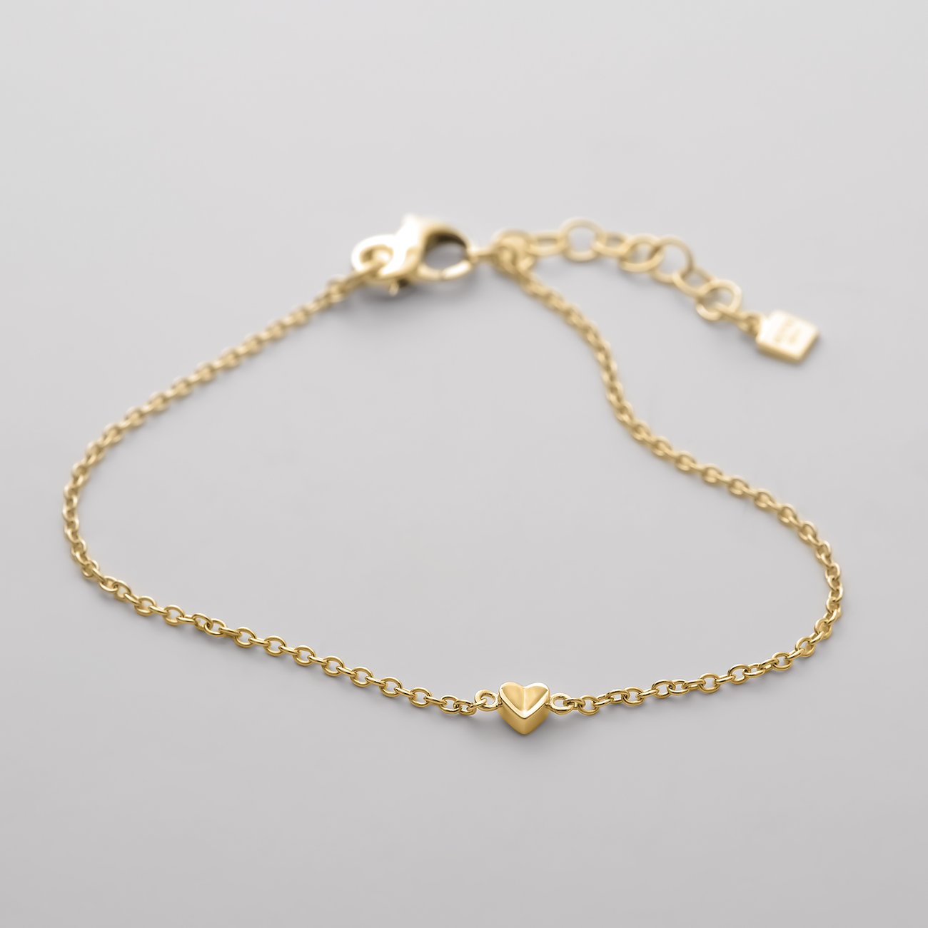 Ett JETTE ärtlänksarmband i återvunnet, guldpläterat 925 sterlingsilver med ett litet hjärthänge i mitten.