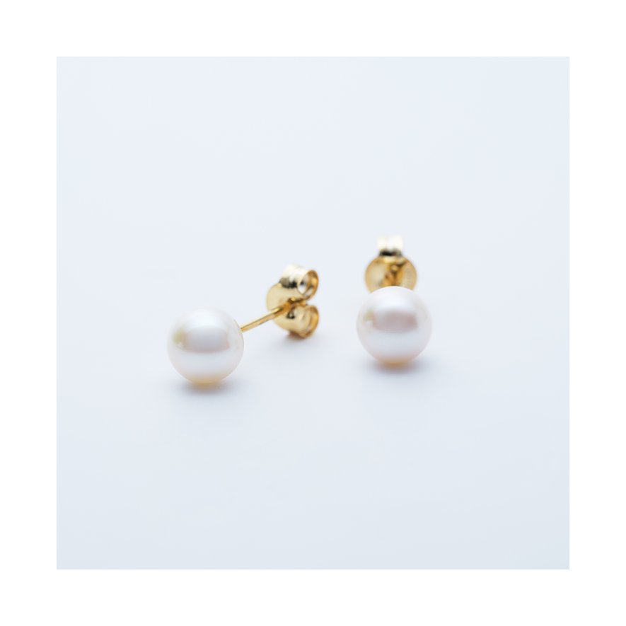 CHRIST Ohrstecker aus 585er Gelbgold mit strahlenden Perlen, eine Nahaufnahme von der Seite.