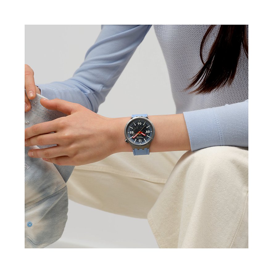 Swatch-klocka med boett i rostfritt stål, analog urtavla och blått armband.