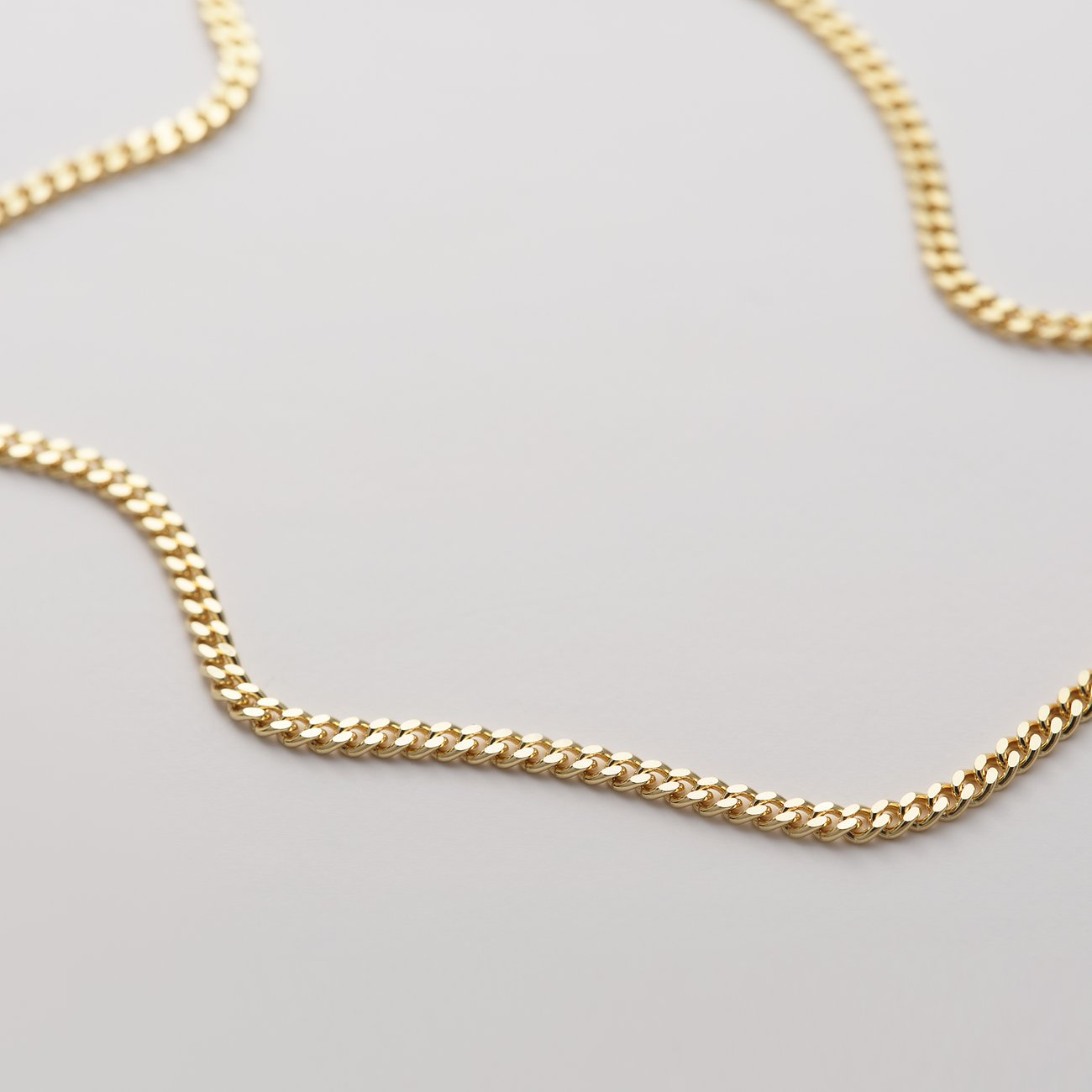CHRIST Armschmuck aus 375er Gelbgold mit feinen Gliedern. Die goldene Kette ist sanft geschwungen und reflektiert.