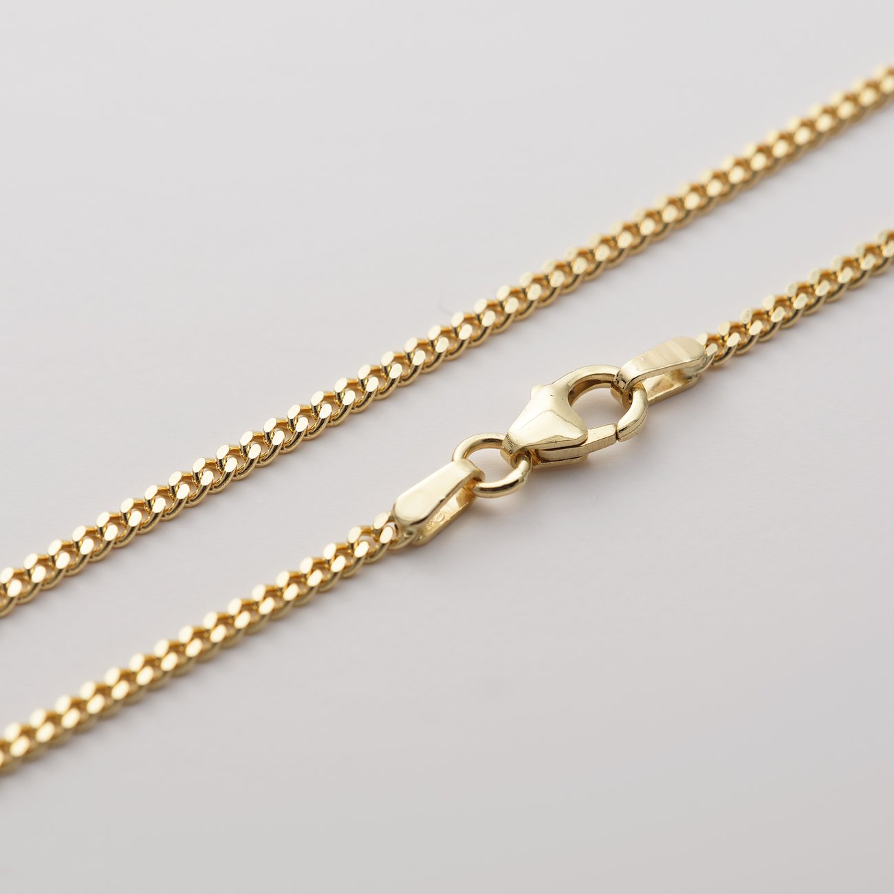 CHRIST 375 Gelbgold Armschmuck mit Karabinerverschluss, schräg liegend dargestellt.