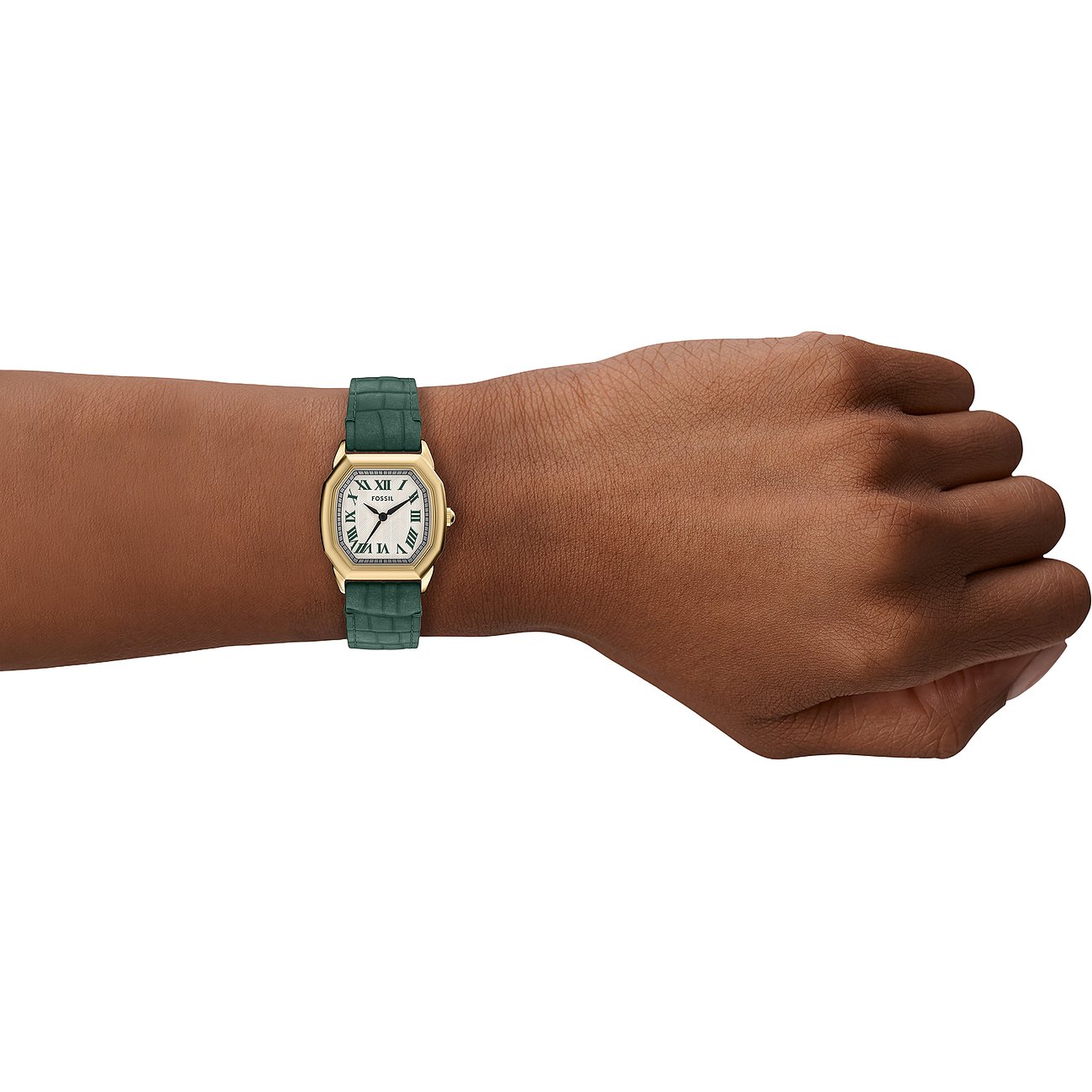 Eine Fossil Damenuhr aus goldfarbenem Edelstahl mit einem grünen, geprägten Armband wird am Handgelenk getragen.