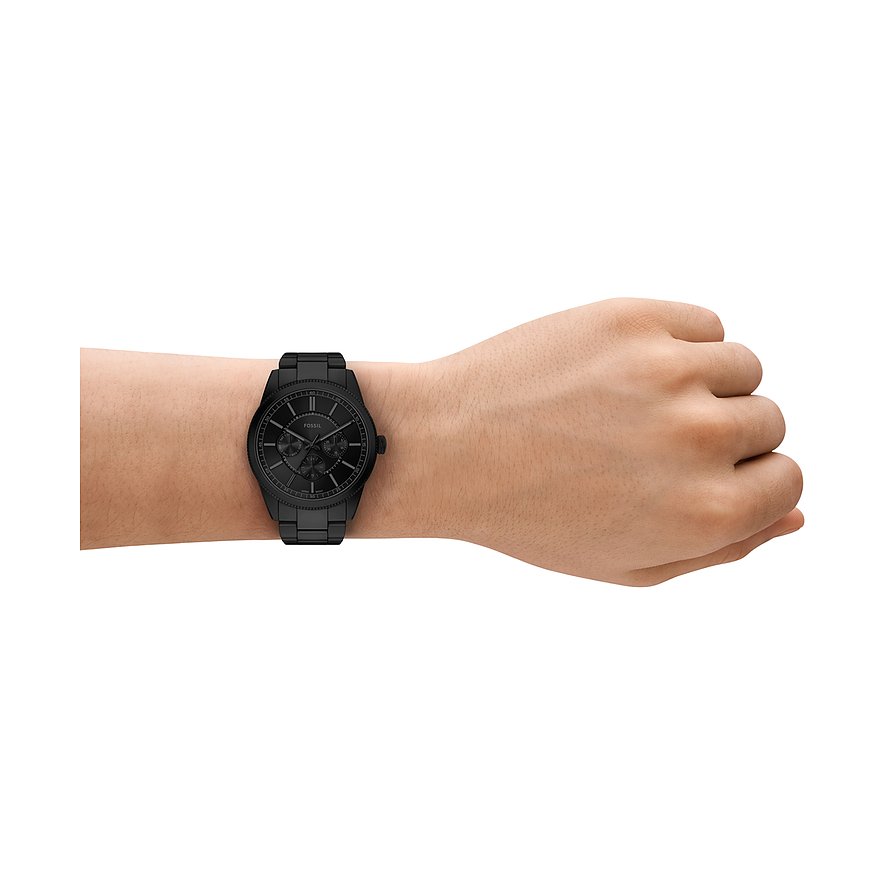 En Fossil herrklocka i svart rostfritt stål på en modells handled. Närbild från sidan.