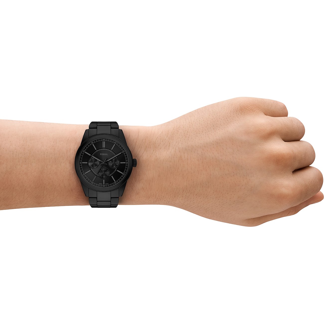 En Fossil herrklocka i svart rostfritt stål på en modells handled. Närbild från sidan.