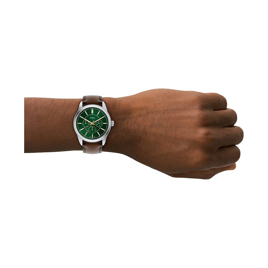 Eine Fossil Herrenuhr aus Edelstahl mit braunem Lederarmband und grünem Zifferblatt ist am Handgelenk zu sehen.