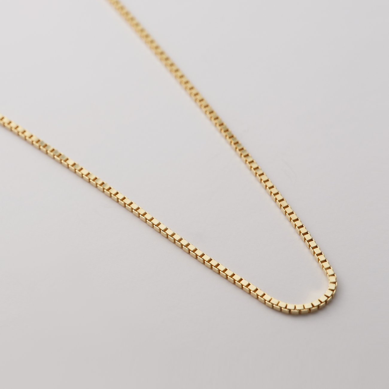 CHRIST Halsschmuck aus Gelbgold, Detailansicht einer feinen Kette mit Würfelmusterung