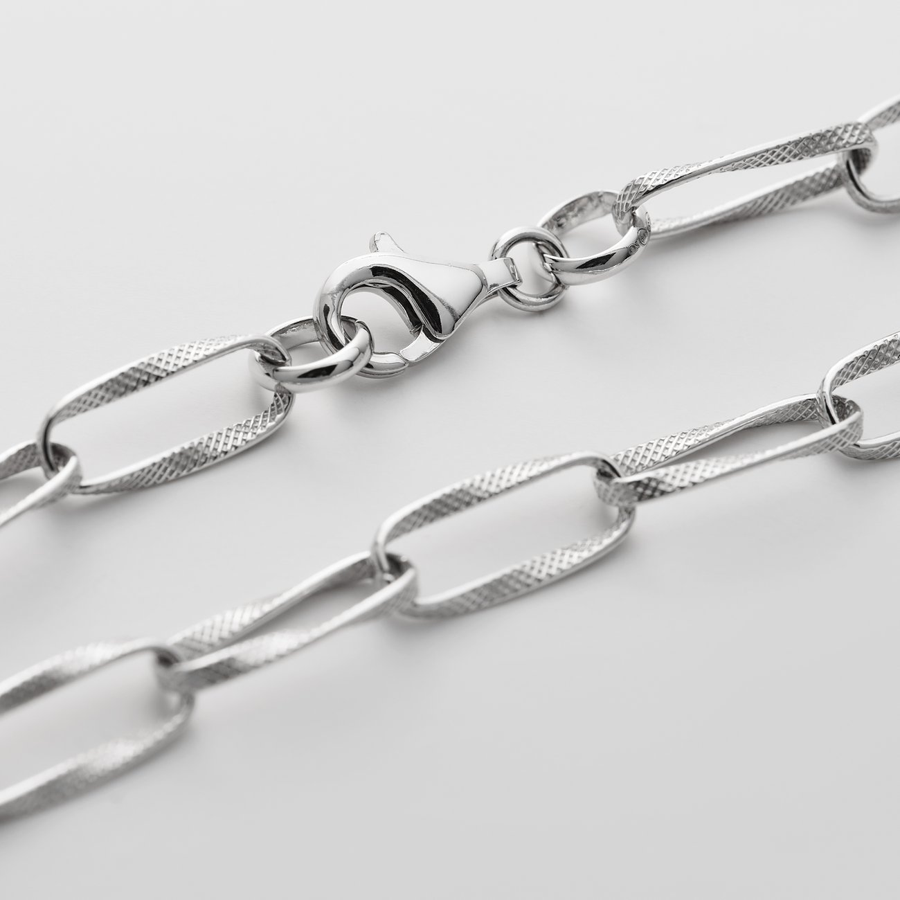 Närbild CHRIST armband i återvunnet 925 silver med strukturerade, avlånga länkar och karbinhake.