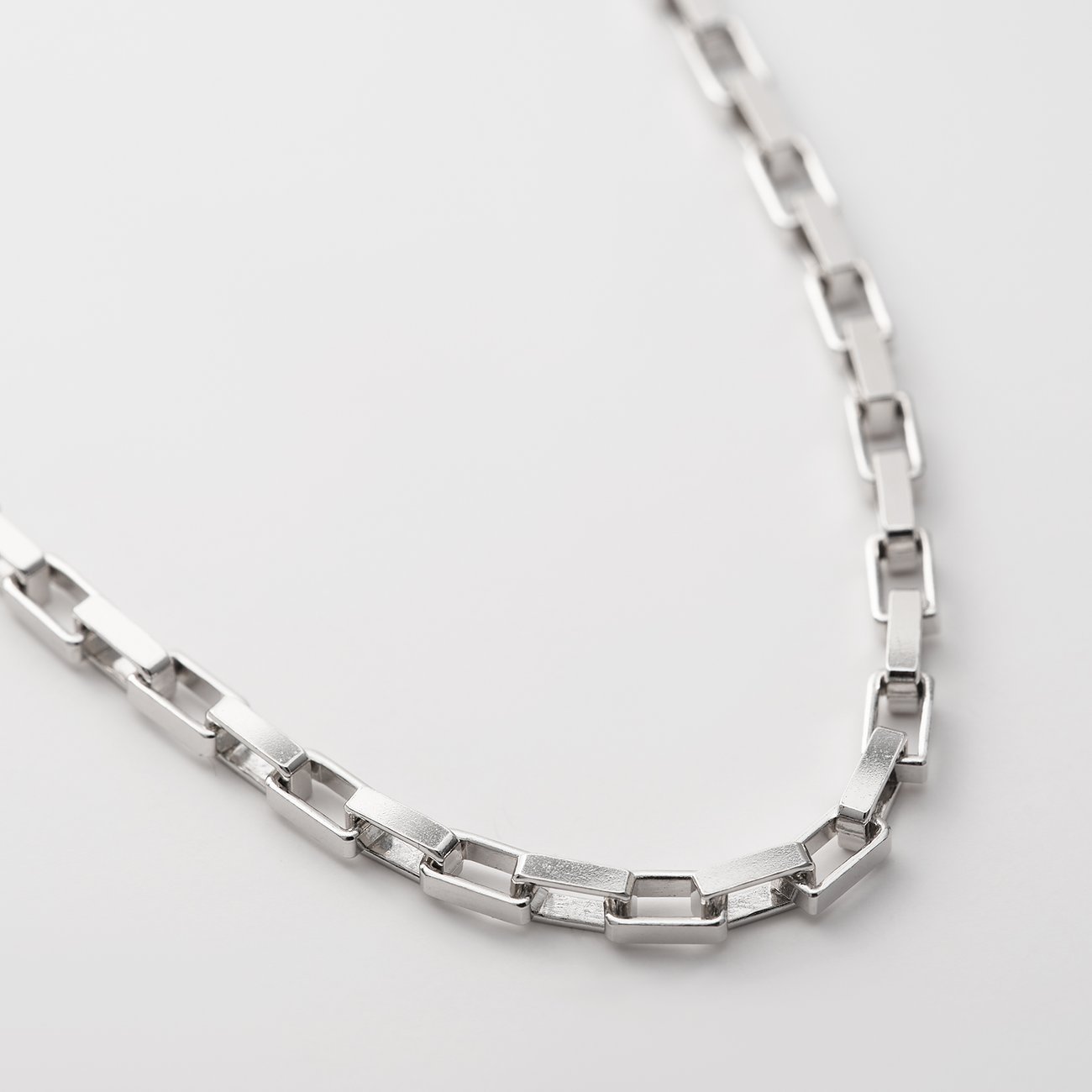 Nahaufnahme einer recycelten CHRIST Silber-Halskette mit rechteckigen Gliedern, diagonal positioniert.