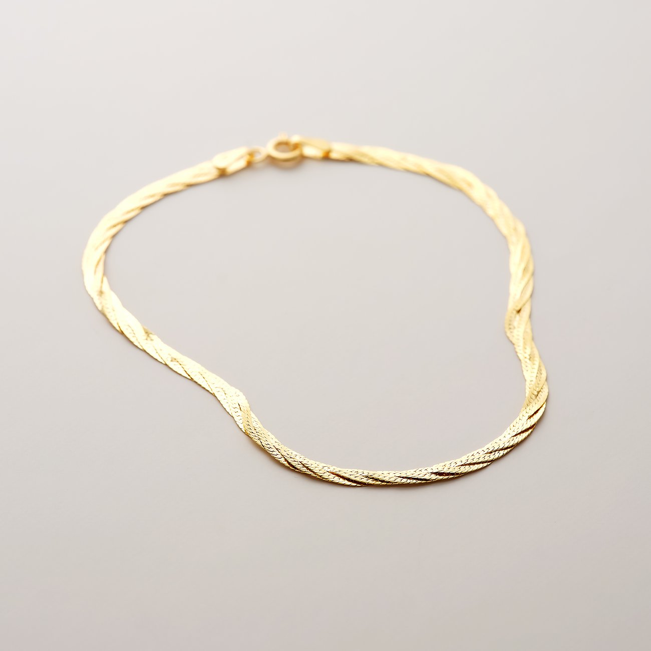 CHRIST Armband aus gedrehtem 585 Gelbgold im Draufsicht. Das Goldarmband liegt leicht gewellt.