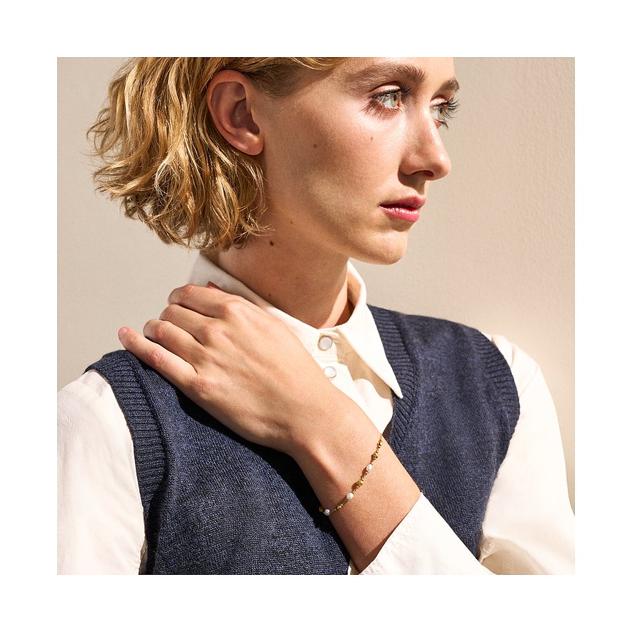 Model trägt ein Skagen Armband aus Edelstahl mit Perlen, das sich elegant um ihr rechtes Handgelenk schmiegt.