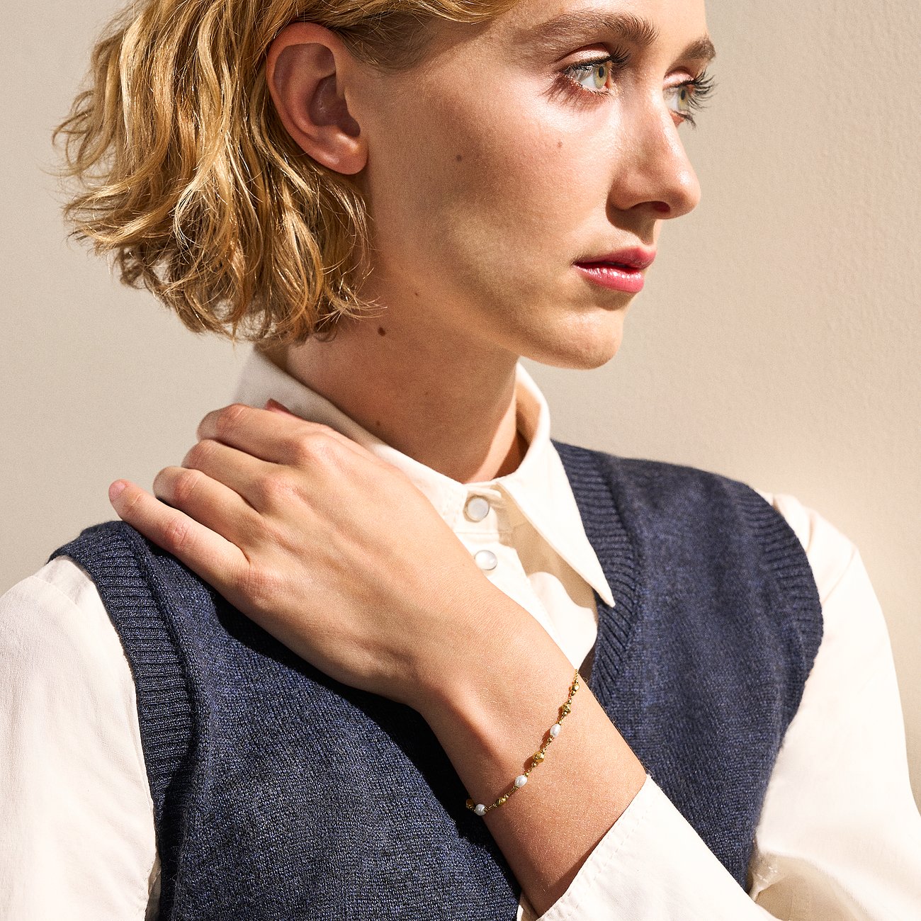 Model trägt ein Skagen Armband aus Edelstahl mit Perlen, das sich elegant um ihr rechtes Handgelenk schmiegt.