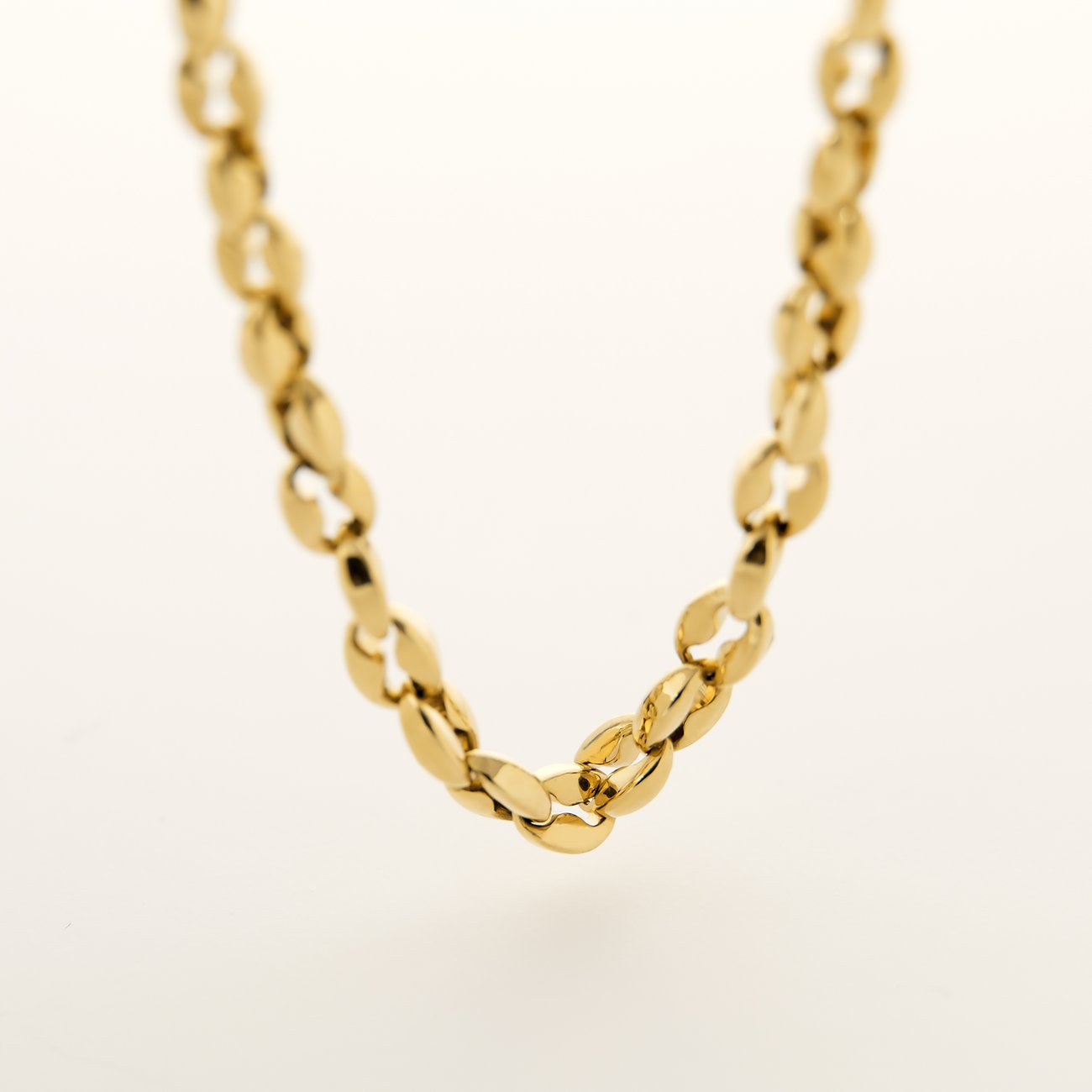 FAVS Halsschmuck aus glänzendem goldfarbenem Edelstahl. Die Kette hat eine detaillierte, engmaschige Struktur.