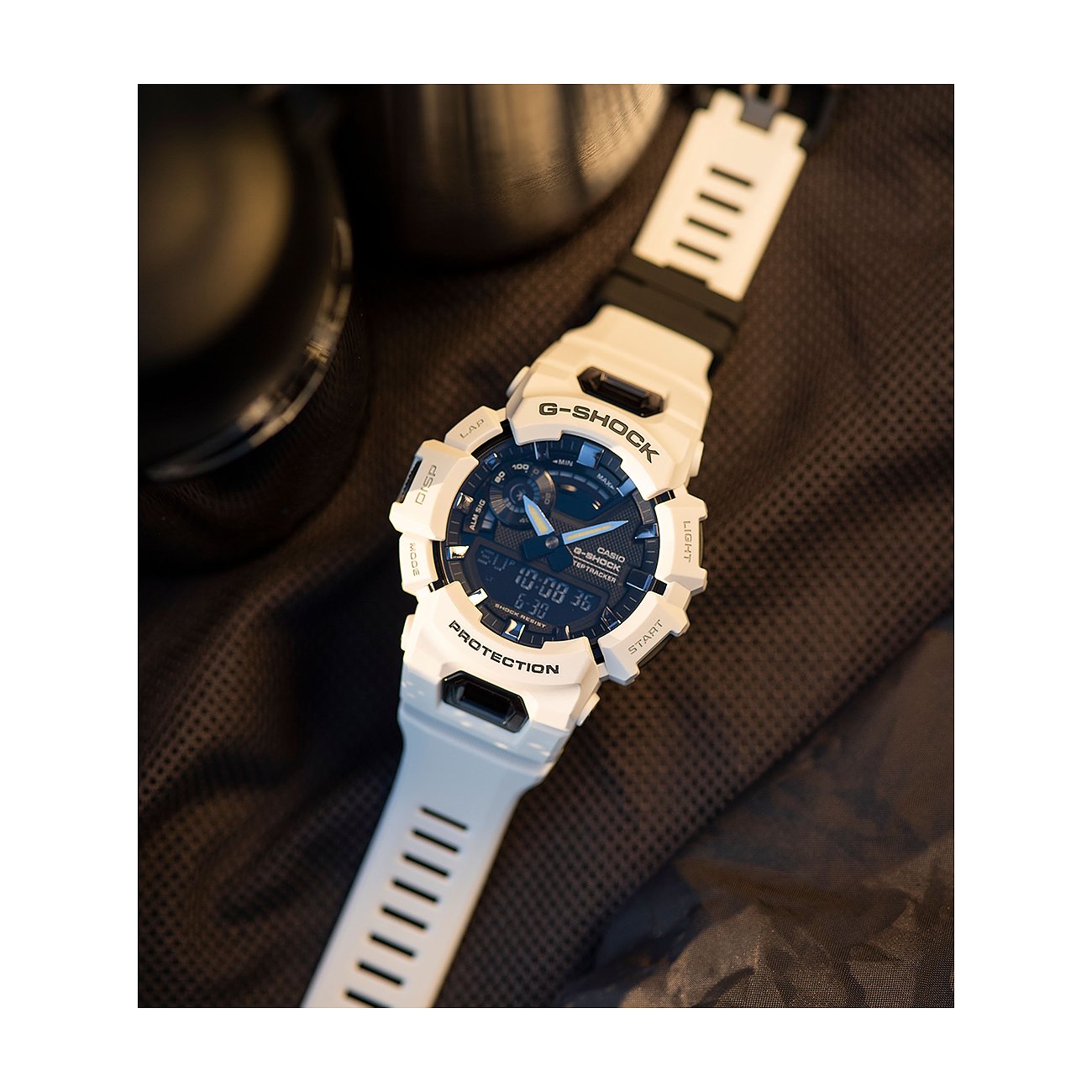 Casio Herrenuhr im Detail, Gehäuse und Resin-Armband sind weiß. Die Uhr liegt auf einem dunklen Textil.