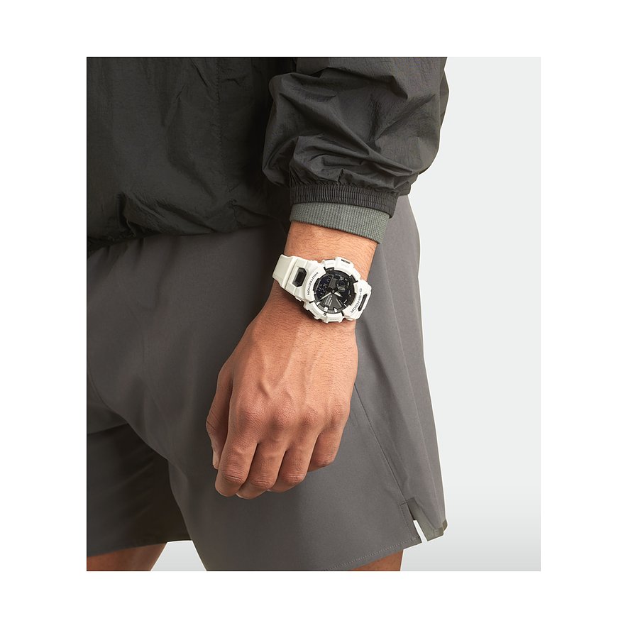 Ein Mann trägt eine weiße Casio Herrenuhr aus Resin am Handgelenk, passend zu seiner Sportkleidung.