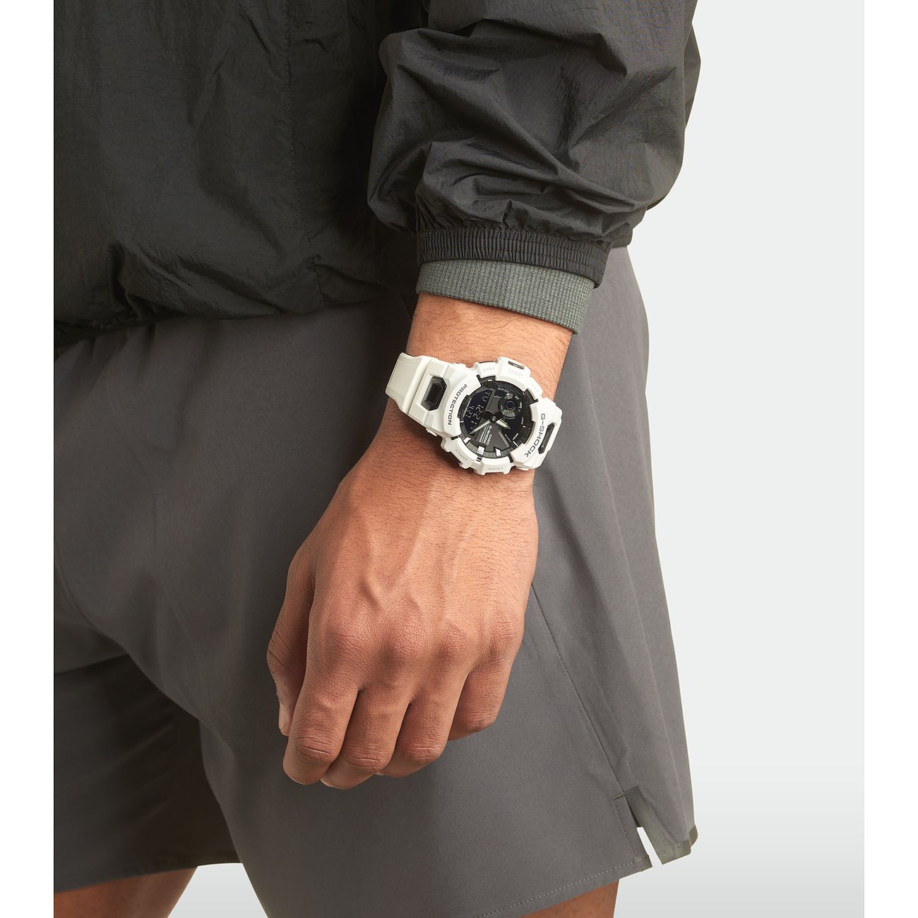 Ein Mann trägt eine weiße Casio Herrenuhr aus Resin am Handgelenk, passend zu seiner Sportkleidung.