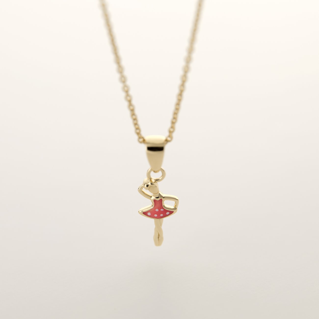 FAVS Halsschmuck: Eine goldene Halskette mit einem kleinen Ballerinaanhänger aus Gold und pinker Emaille.