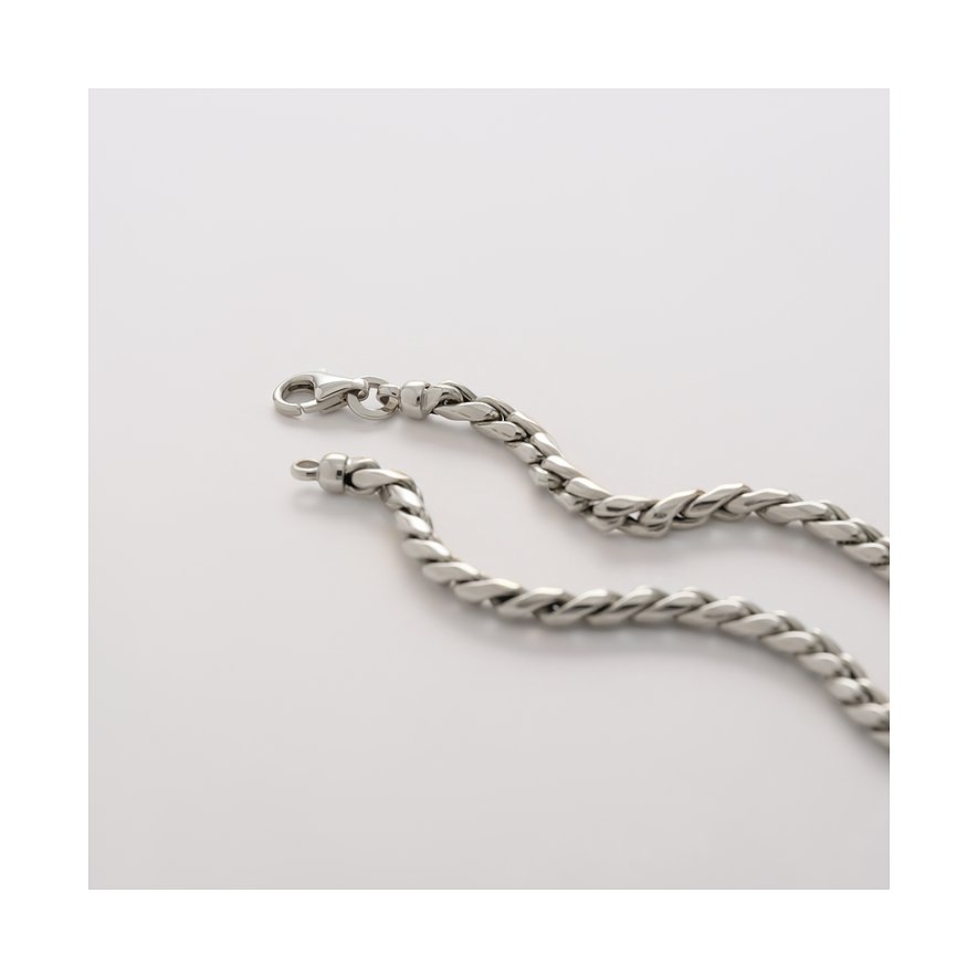 Nahaufnahme einer CHRIST Halskette aus 585er Weißgold, elegant geschlängelt auf glatter Fläche, zeigt Karabinerverschluss.