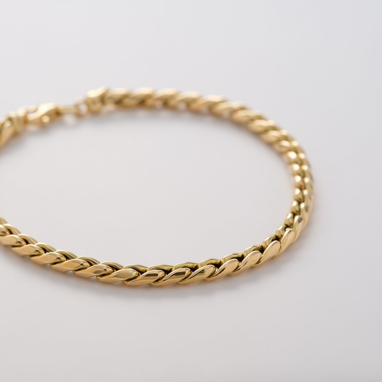 CHRIST Armschmuck aus 585 Gelbgold mit geflochtenen Gliedern. Die Gliederung ist auf weißem Hintergrund scharf zu sehen.
