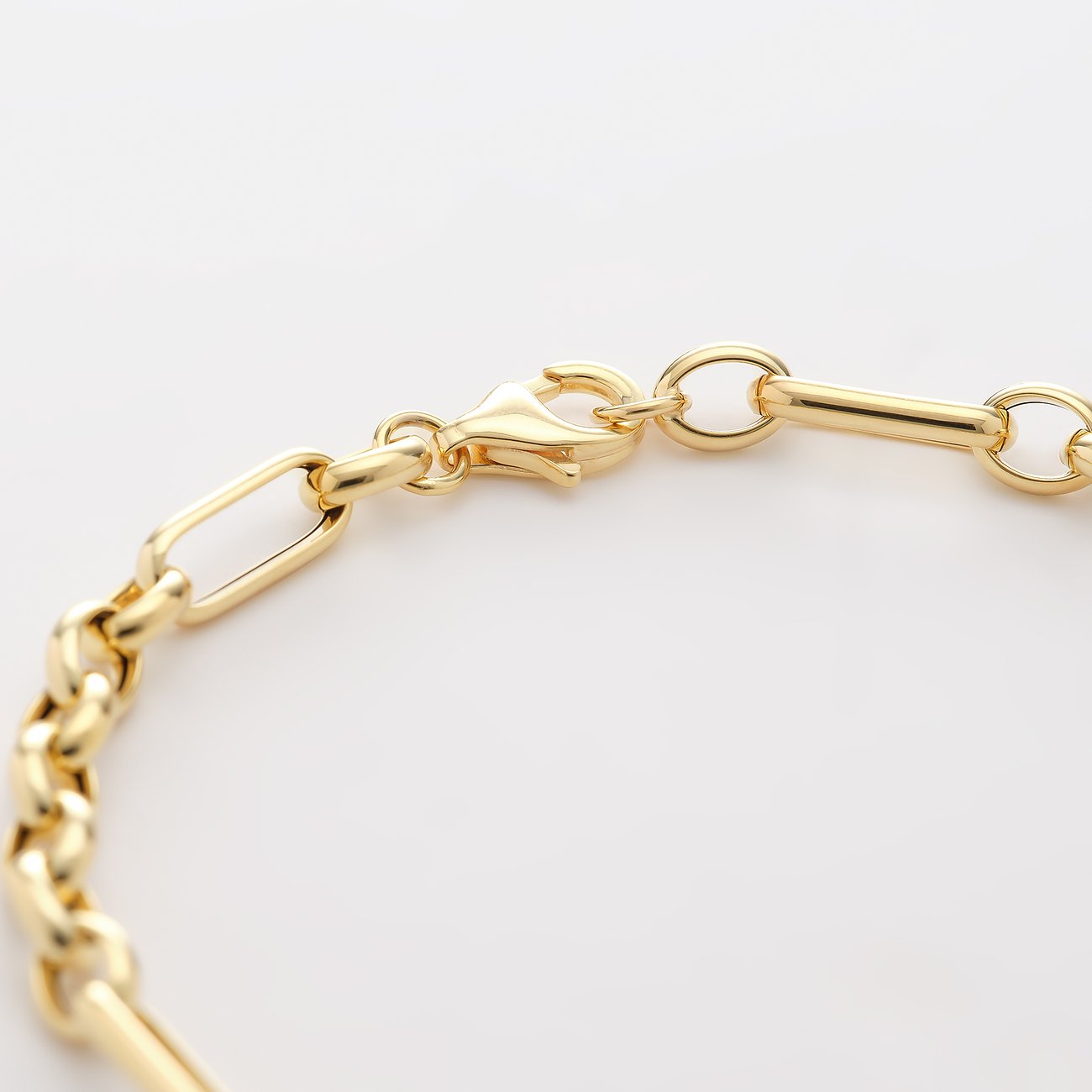 Nahaufnahme des Verschlusses eines CHRIST Armbands aus 585 Gelbgold mit gemischten Kettengliedern und Karabinerhaken.