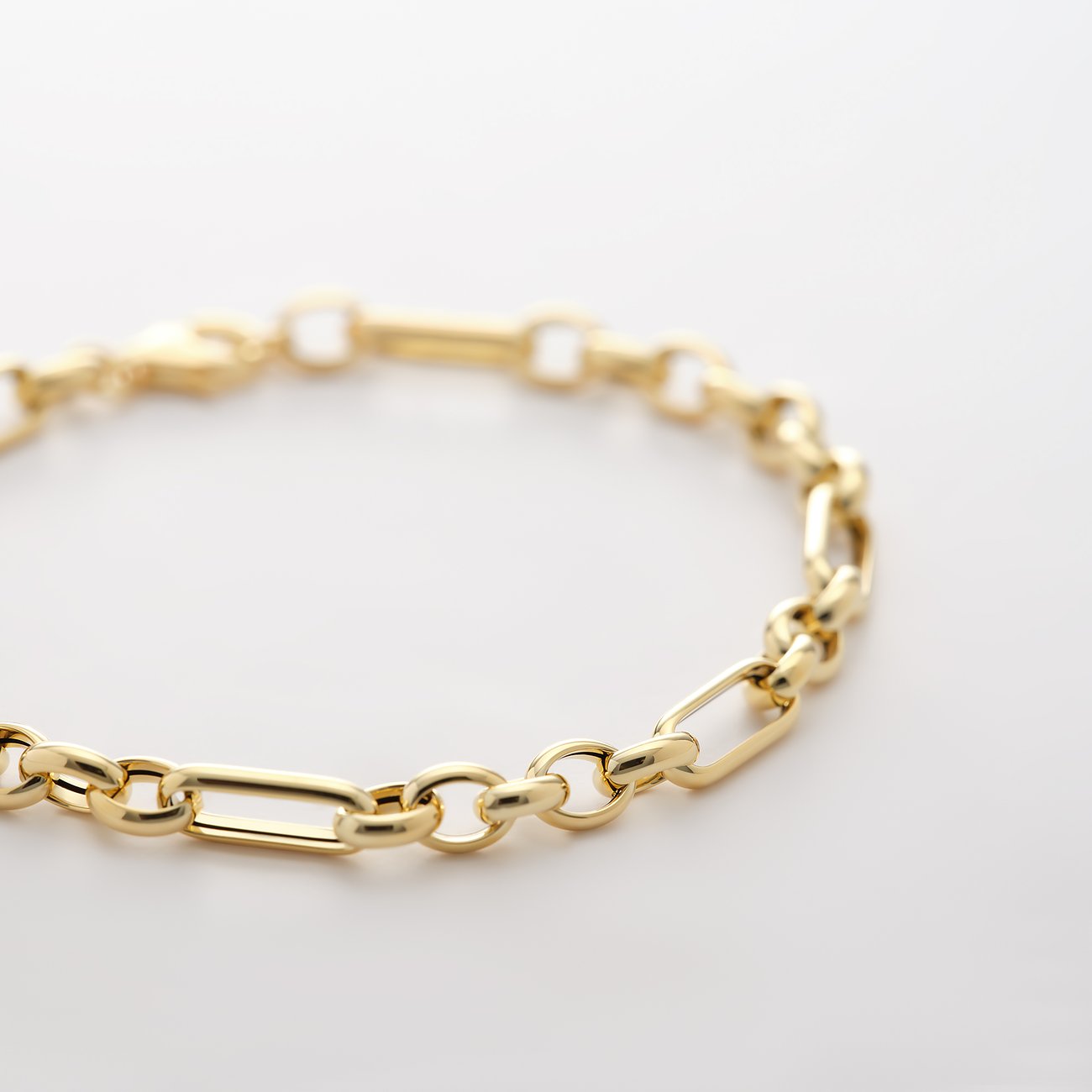 Nahaufnahme eines CHRIST 585 Gelbgold Armkettchens aus abwechselnd ovalen und länglichen Kettengliedern.