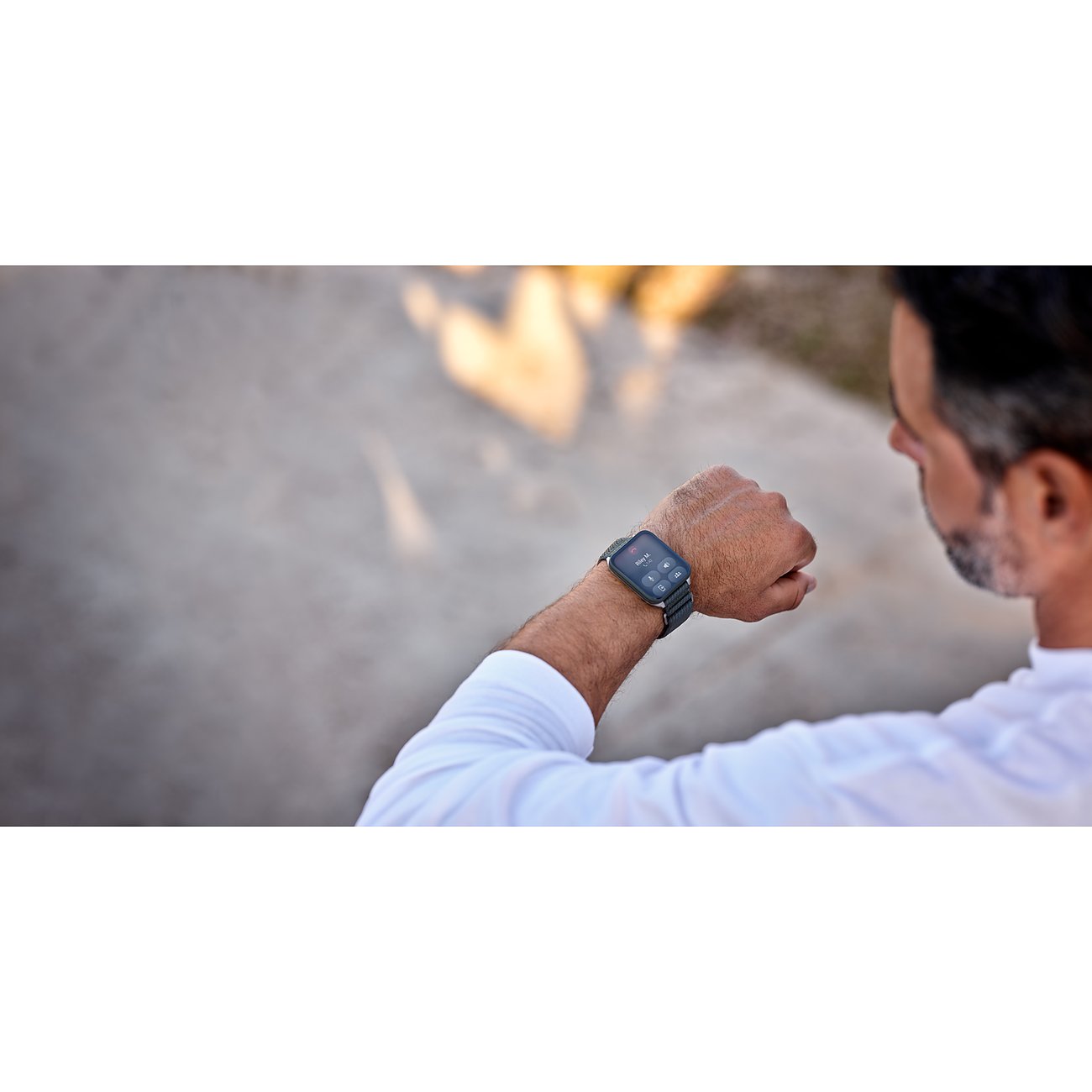 Eine Person trägt die Garmin Smartwatch aus Kunststoff und Metall am Handgelenk und blickt darauf.