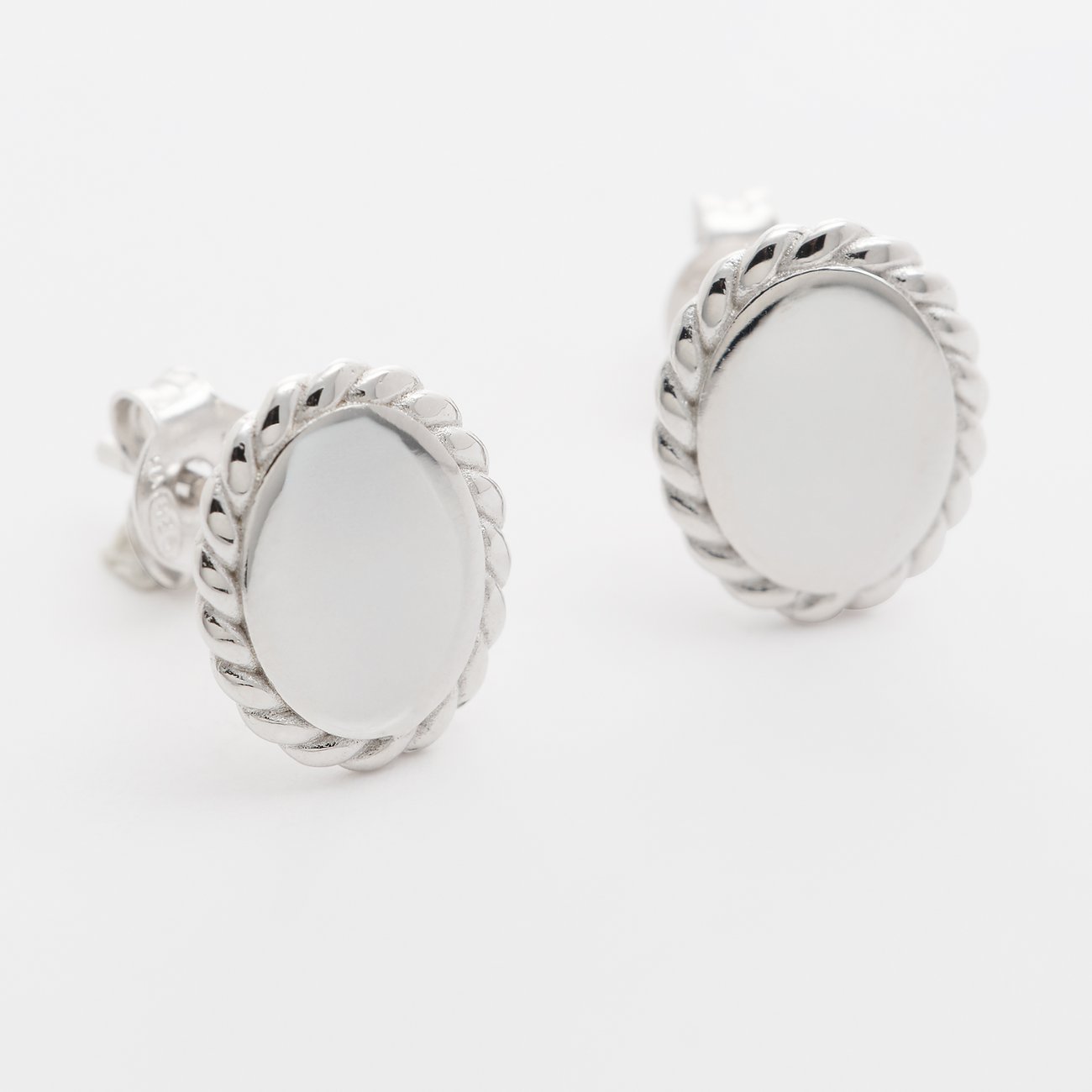 Clous d'oreilles FAVS en argent 925, surface ovale brillante et bord torsadé sur fond blanc.