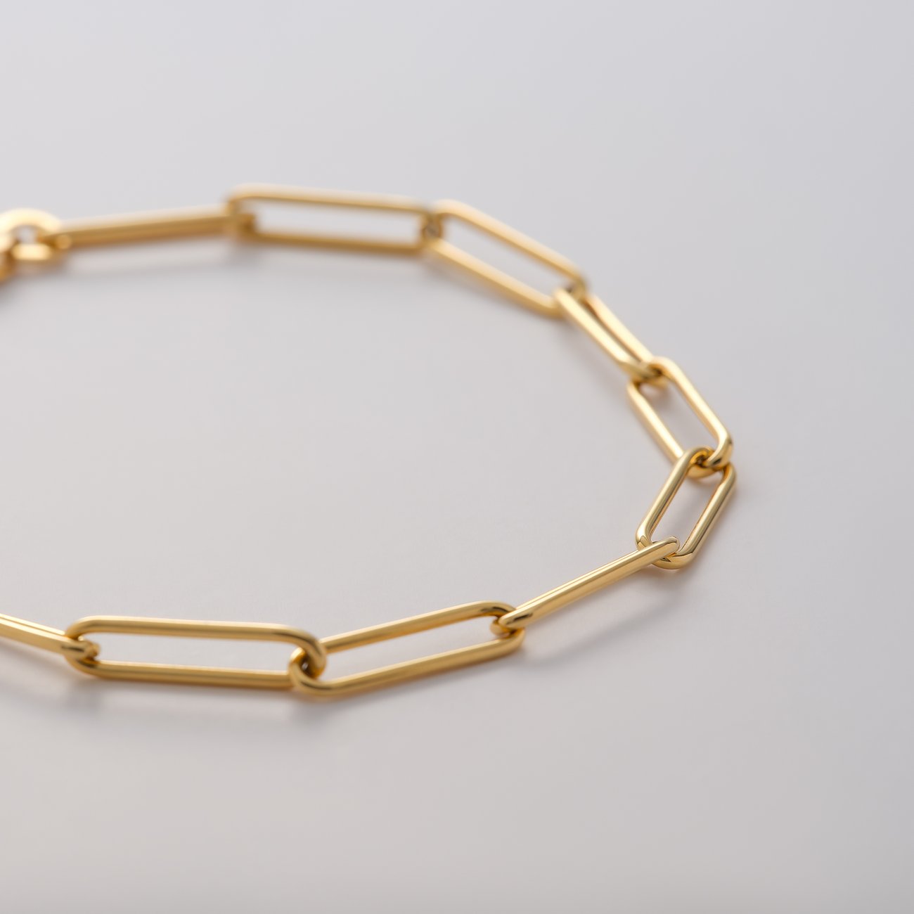 Ein Detailfoto des CHRIST Armschmucks aus 375er Gelbgold, der aus einer langen Kette von abgerundeten Gliedern besteht.