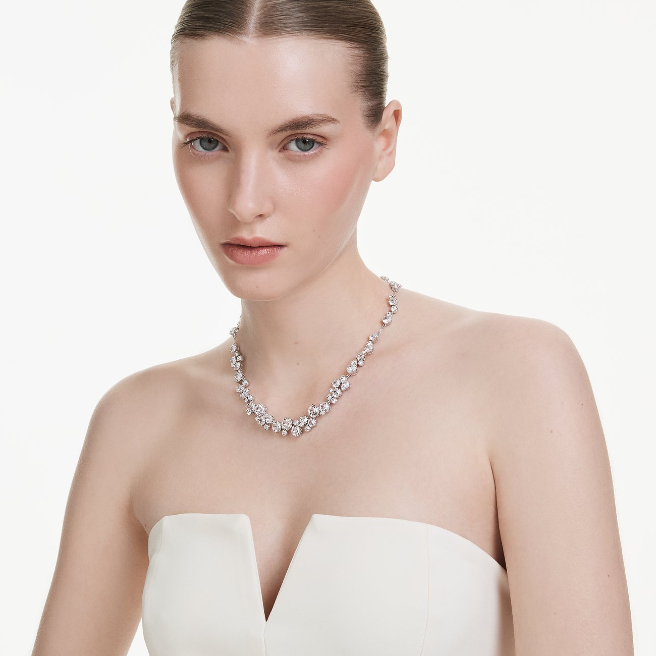 Close-up van een vrouw die een metalen Swarovski ketting draagt met sprankelende Swarovski kristallen.