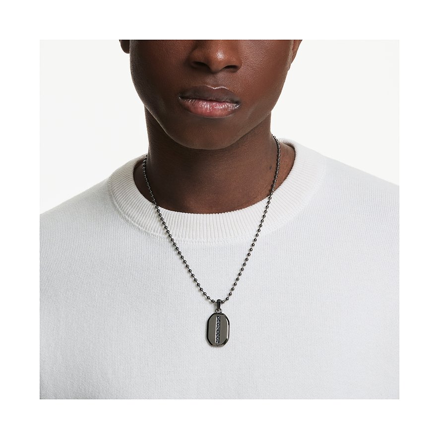 Nahaufnahme eines Modells, das eine Swarovski Halskette mit einem dunklen Anhänger aus Metall und Swarovski-Kristallen trägt.