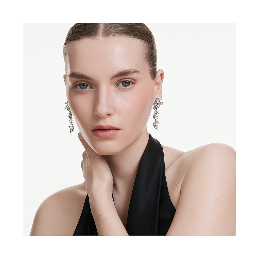 Model draagt Swarovski metalen oorbellen met stijlvolle Swarovski-kristallen in een asymmetrische formatie.
