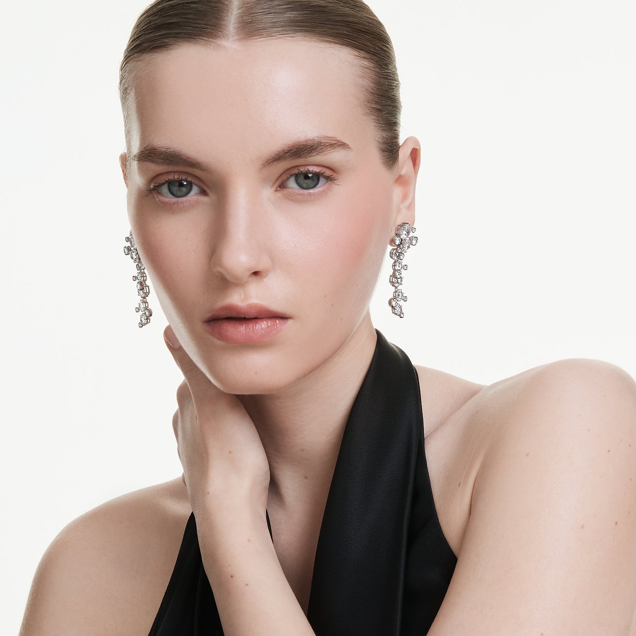 Model draagt Swarovski metalen oorbellen met stijlvolle Swarovski-kristallen in een asymmetrische formatie.