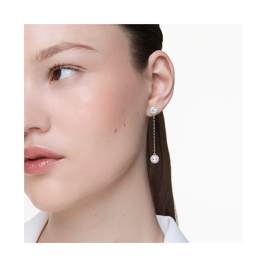 Nahaufnahme einer Frau mit einem einzigen langen Swarovski Ohrschmuck aus Metall und Farbedelsteinen.