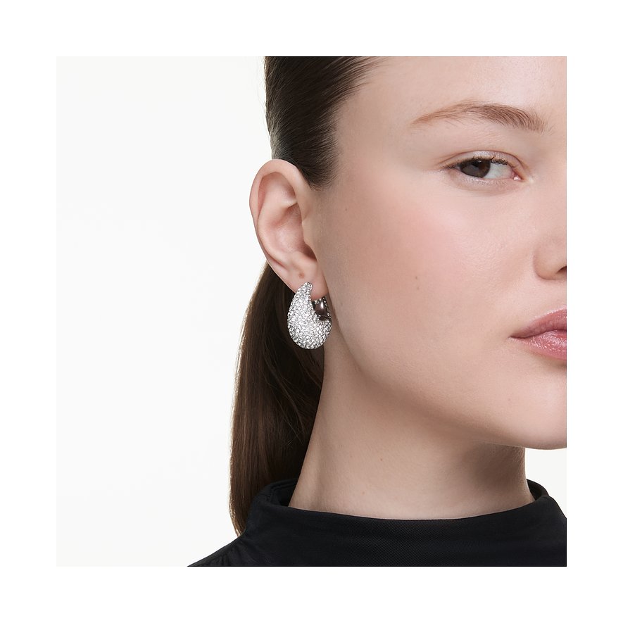 Ein Swarovski Tropfenohrring aus Metall mit funkelnden Swarovski-Kristallen ziert das Ohr einer Frau.