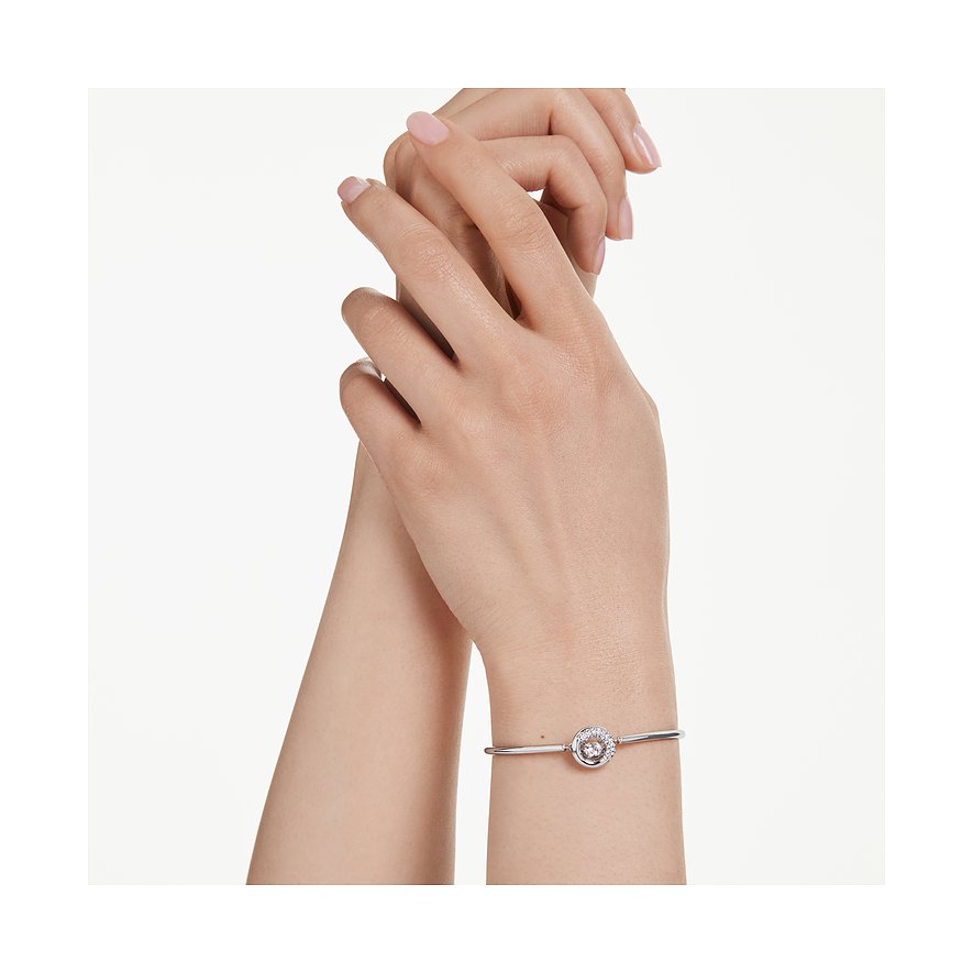 Am Handgelenk getragener Swarovski Armreif aus Metall mit einem rosafarbenen Swarovski-Kristall in der Mitte.