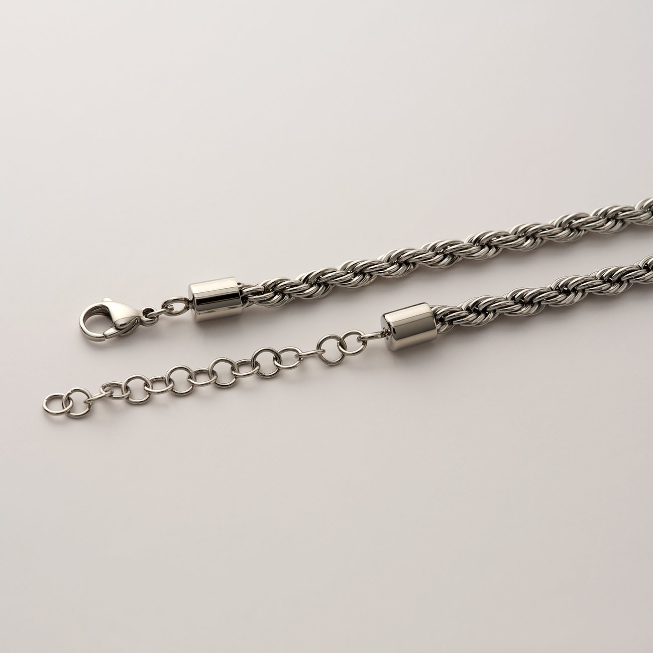 FAVS Halsschmuck: Eine nah aufgenommene, gedrehte Halskette aus Edelstahl in Silber mit einem Karabinerverschluss.