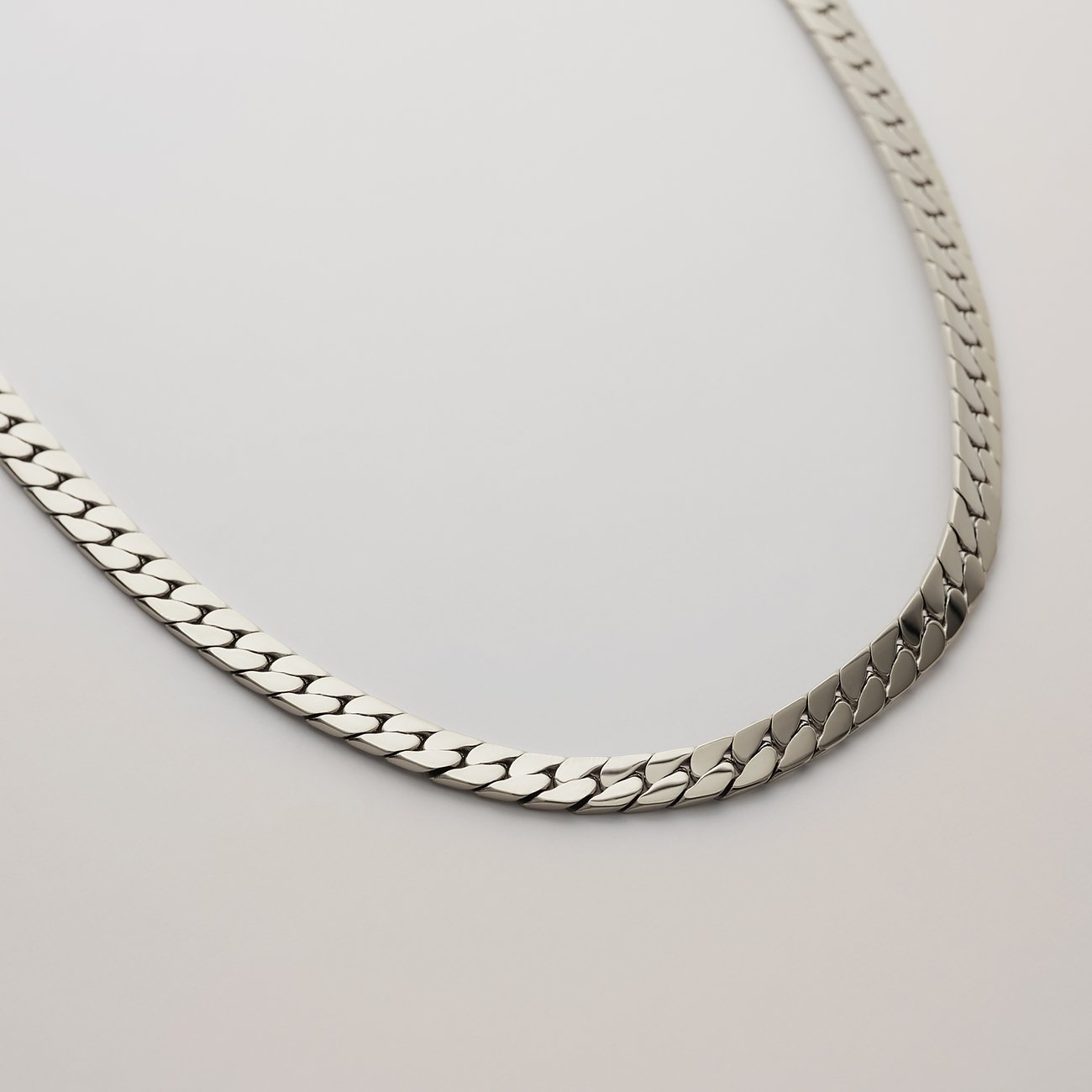 Collier FAVS en acier inoxydable brillant couleur argent, posé à plat sur un fond clair.