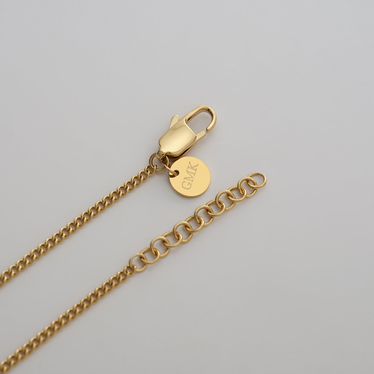 Nahaufnahme des Verschlusses einer Guido Maria Kretschmer Halskette aus goldfarbenem Edelstahl.