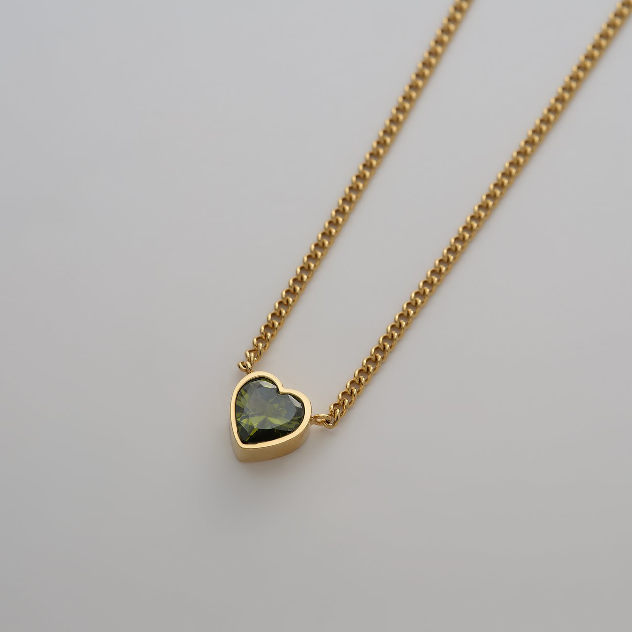 Guido Maria Kretschmer Halskette aus goldfarbenem Edelstahl mit herzförmigem, olivgrünem Zirkonia.