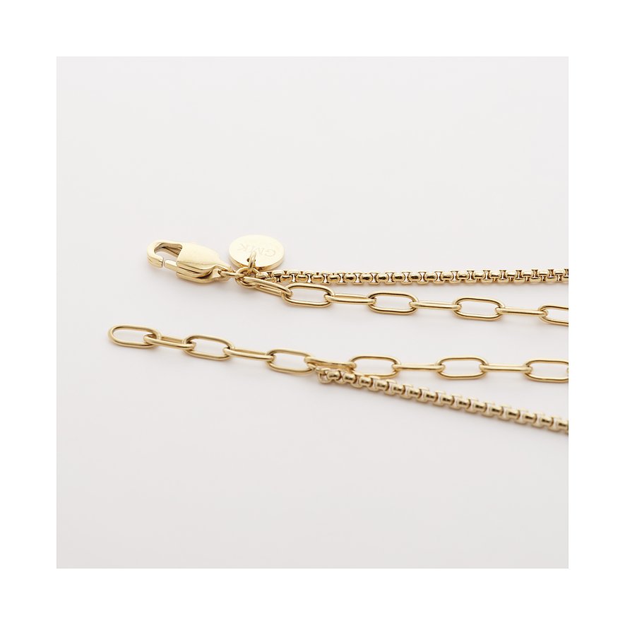 Detailaufnahme einer Guido Maria Kretschmer Armbandverlängerung aus goldfarbenem Edelstahl mit Karabinerverschluss.