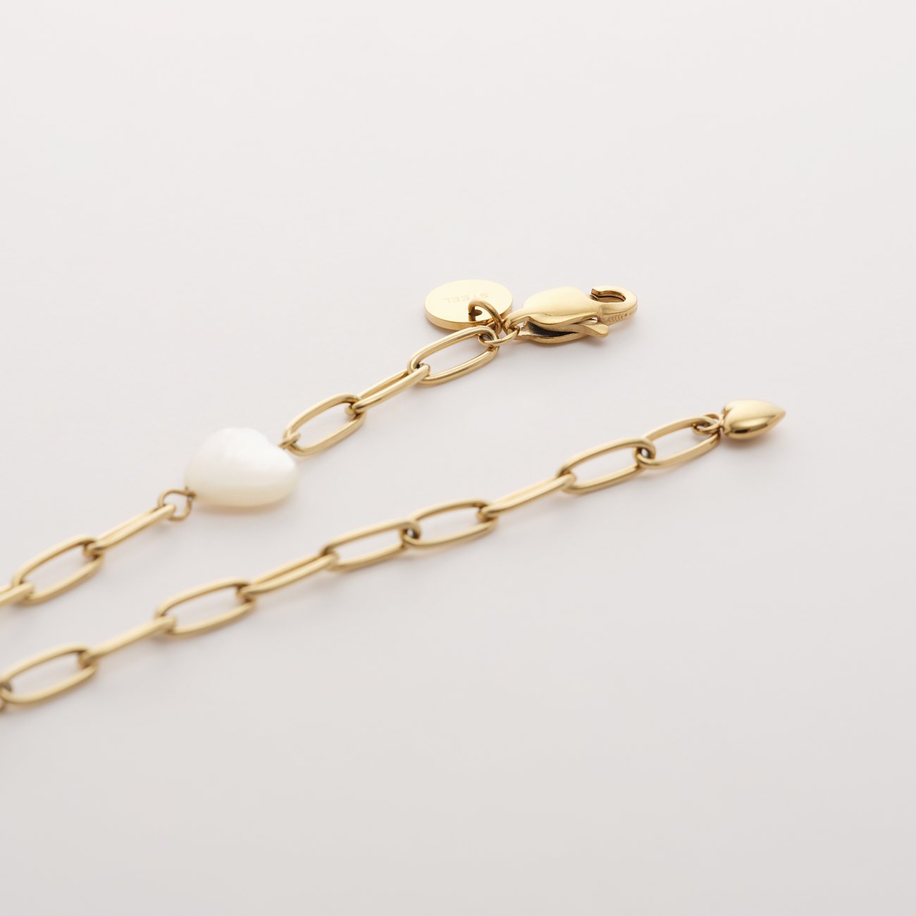 Bracelet Guido Maria Kretschmer en acier inoxydable doré avec pendentif cœur en nacre.