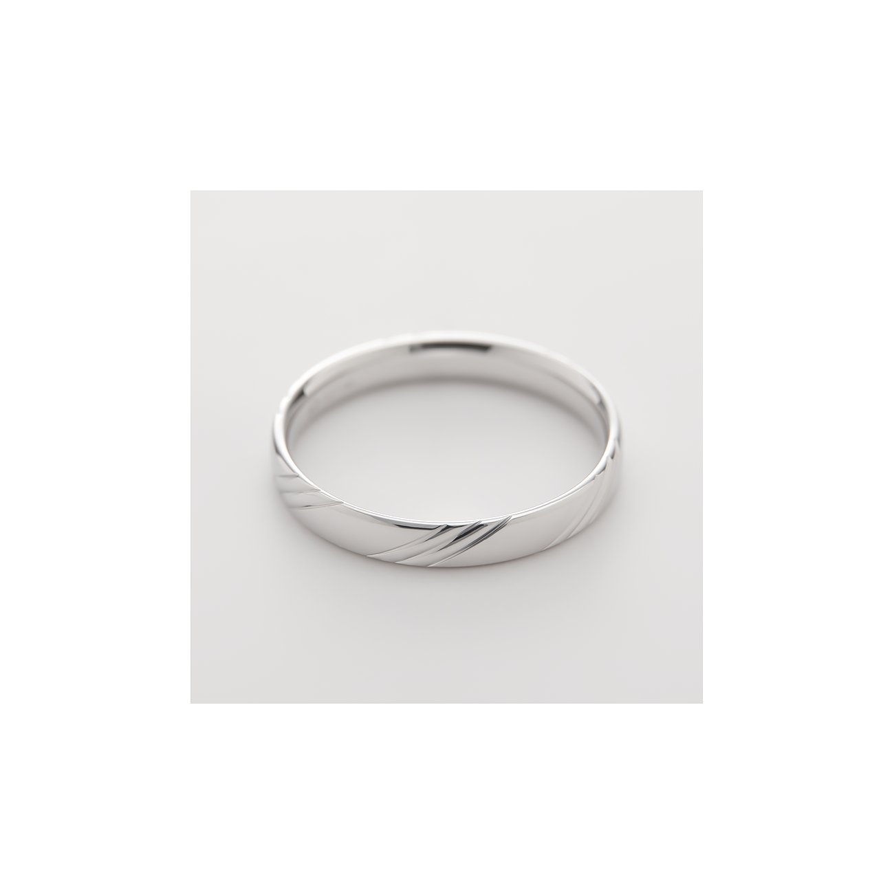 CHRIST ring af 375 hvidguld med diagonal rillestruktur, fotograferet fra øverste højre vinkel.